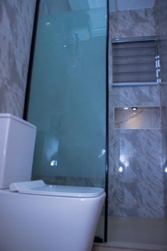 a bathroom with a toilet and a glass shower at Dream Nest in Benin City