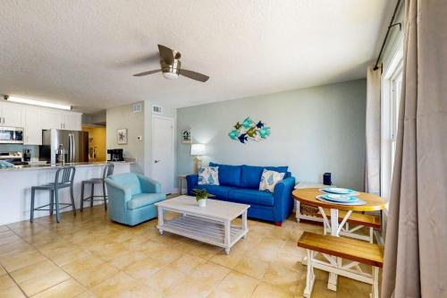 a living room with a blue couch and a table at Spacious Condo with full kitchen shared pool and beach access in Perdido Key