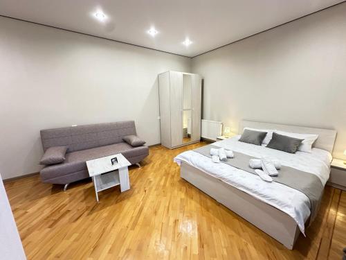 a bedroom with a large bed and a couch at Guest House Chkalovka Garden in Sevan