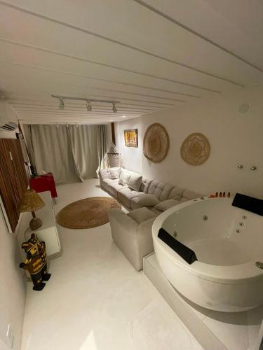 a large living room with a tub and a couch at Pier Beach Club in Cabo Frio