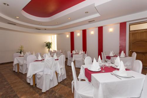 a banquet hall with white tables and white chairs at Guest House Mamut in Kaštela