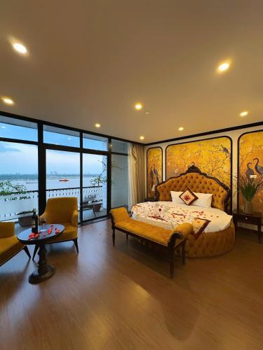 a bedroom with a bed and a couch and a table at Sunrise Hanoi Hotel in Hanoi