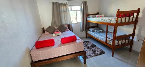 a bedroom with a bunk bed with red pillows at recanto provetá ILHA GRANDE in Praia de Provetá 