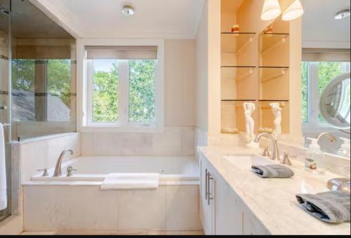 a bathroom with two sinks and a large tub at Unique Home - Upper Toronto Beaches in Toronto