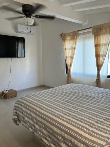 a bedroom with a bed and a ceiling fan at Departamento in Lo de Marcos