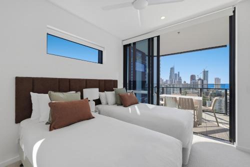 two beds in a room with a view of the city at Amaya in Gold Coast