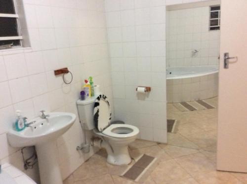 a bathroom with a toilet and a sink and a tub at Chiloto Guest House in Kasane