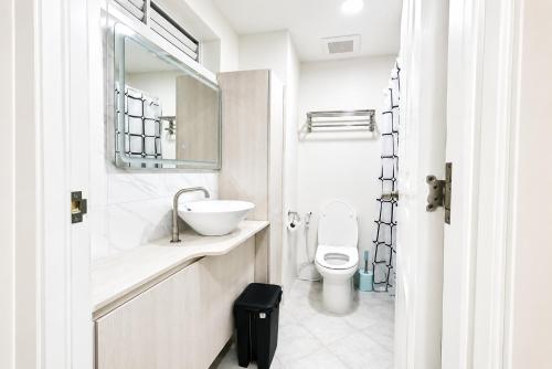 a white bathroom with a sink and a toilet at 2 Mins Away from Mactan Cebu Airport in Pusok