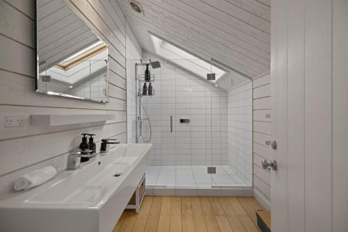 a white bathroom with a sink and a shower at Toi Point Lodge in Queenstown