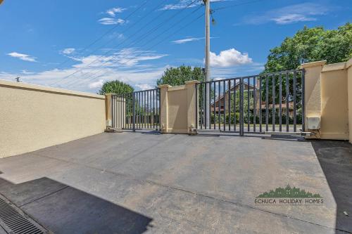 a driveway with a gate and a fence at Llewoh on Crofton in Echuca