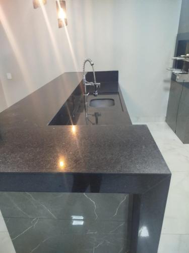a kitchen counter with a sink and a faucet at Casa com Ar-Condicionado in Formosa