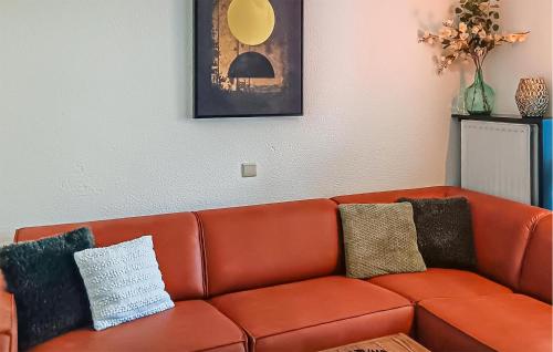 a orange couch with pillows on it in a living room at Golf 3 in Middelkerke