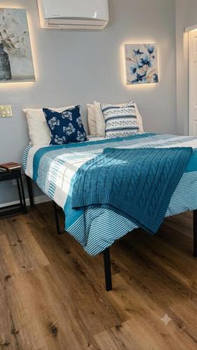 a bed with blue and white sheets and pillows at Stylish Studio in Oleander Close to Downtown in Bakersfield
