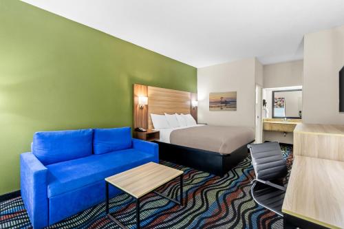 a hotel room with a bed and a blue couch at Quality Inn Walterboro I-95 in Walterboro