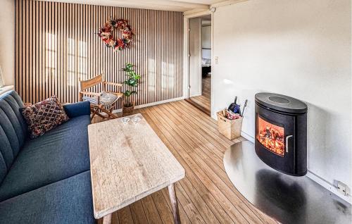 a living room with a blue couch and a fireplace at Cozy Home In Silkeborg With Wifi in Silkeborg