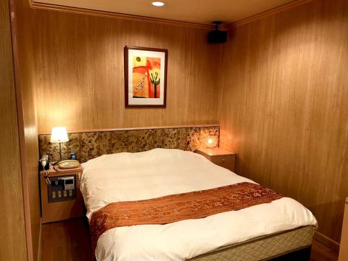 a hotel room with a bed and two night stands at ホテル タイムレス 明石 男塾ホテルグループ in Akashi