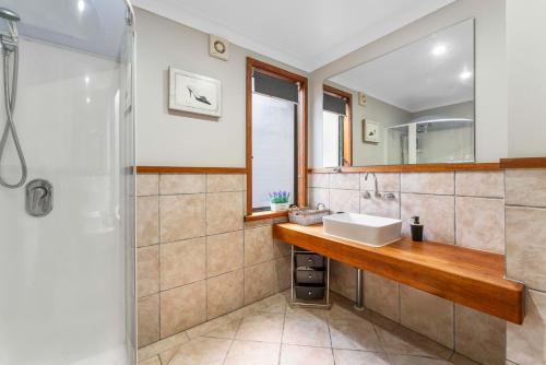 a bathroom with a sink and a mirror at The Nest - Guest House, Acacia Bay, Panoramic Lake Views in Taupo