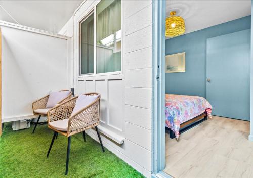 a bedroom with a bed and a chair and a window at One Bed Honolulu Kaaha in Honolulu