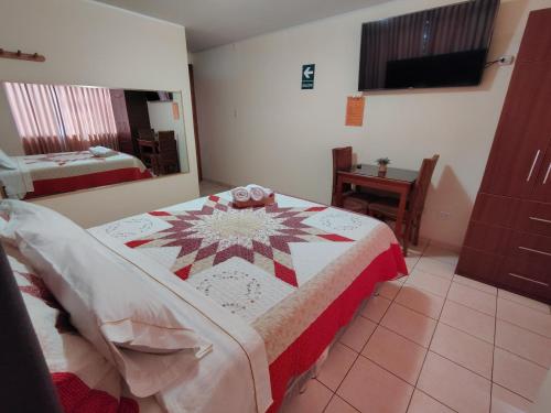 a bedroom with a bed with a quilt on it at Hotel Las Viñas in Huánuco
