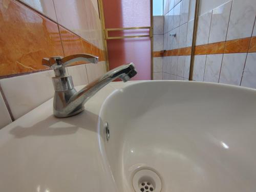 a bathroom sink with a faucet on top of it at Hotel Las Viñas in Huánuco