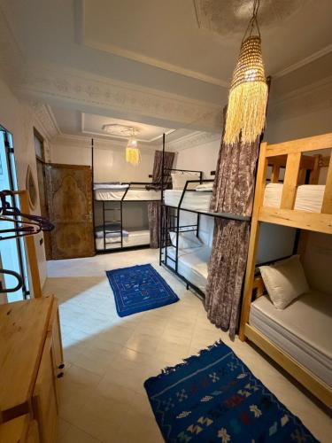 a room with two bunk beds and a table at Mira Guest House in Taghazout