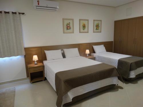 a hotel room with two beds and two lamps at Hotel e Restaurante Sabor de Minas in Salinas