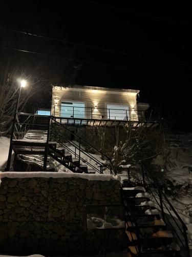 a house in the snow at night with a light at Balcón Austral beautiful apartment with incredible views of the mountains and the city in Ushuaia