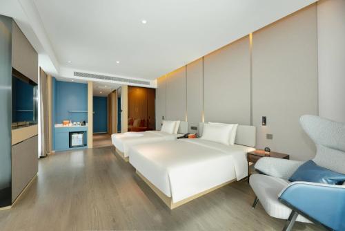 a hotel room with four beds and a couch at Atour Hotel Yan'an Luyi Park in Yan'an