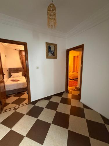 a room with a checkered floor and a bedroom at Mira Guest House in Taghazout