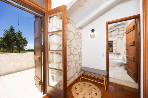 a bathroom with a toilet and a glass door at Villa Boscheto Tria in Agios Leon