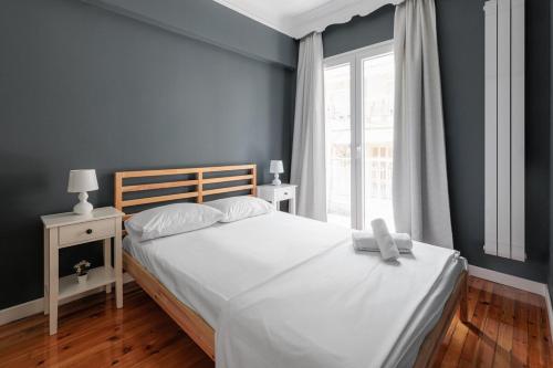 a bedroom with a large white bed with a window at Lumahaus Chamber Palaiologou in Thessaloniki