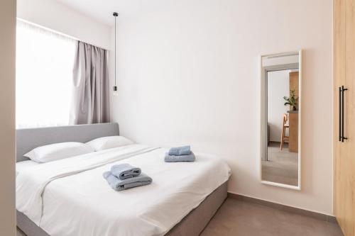 a bedroom with a white bed with towels on it at Skg Cityscape Metropolis in Thessaloniki