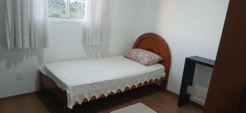 a small bed in a room with a window at Apartamento da Lagoa in Londrina