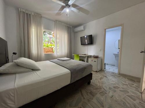 a bedroom with a bed and a ceiling fan at Babilla Suites in Cali