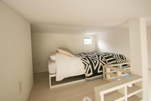 a bedroom with a bed with a zebra print blanket at SCREEN Shibamata 20 mins to Skytree in Tokyo