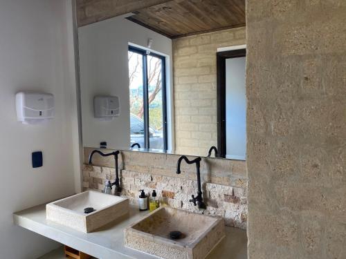a bathroom with a stone sink and a mirror at Casa - Finca Villa Violeta in San Vicente