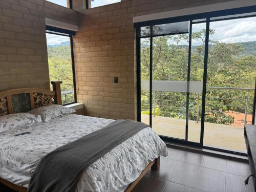 a bedroom with a bed and a large window at Casa - Finca Villa Violeta in San Vicente