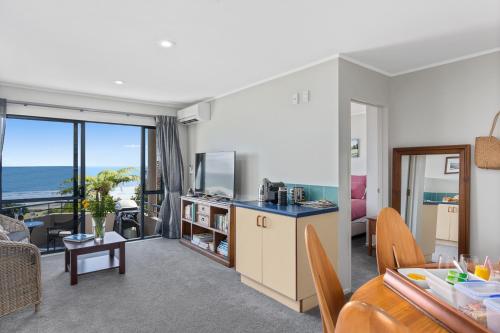 una cucina e un soggiorno con vista sull'oceano di Ohope Heights a Ohope Beach