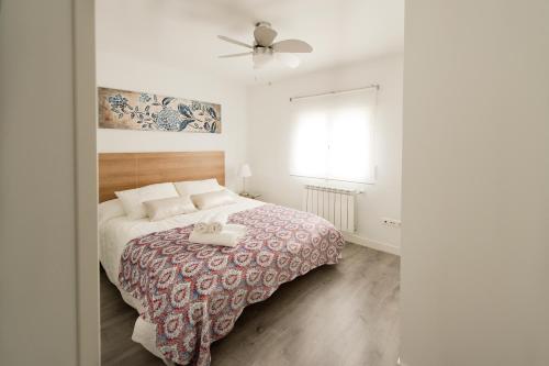 una camera da letto con un letto e un ventilatore a soffitto di Apartamento Turístico la Concordia a Guadalajara