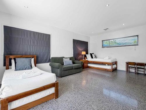 a bedroom with a bed and a couch and a chair at Pindara in Broke