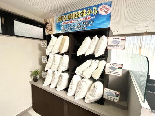 a shelf with a bunch of white shoes on it at サンシティーホテル山代 in Kaga