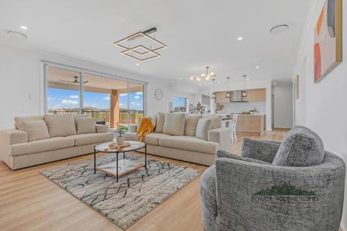 ein Wohnzimmer mit zwei Sofas und einem Tisch in der Unterkunft Riverside Meadows in Echuca
