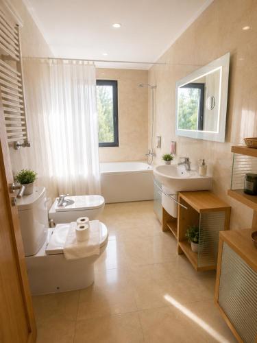 a bathroom with a toilet and a tub and a sink at Bom dia Parque Nações LisboaZ in Lisbon