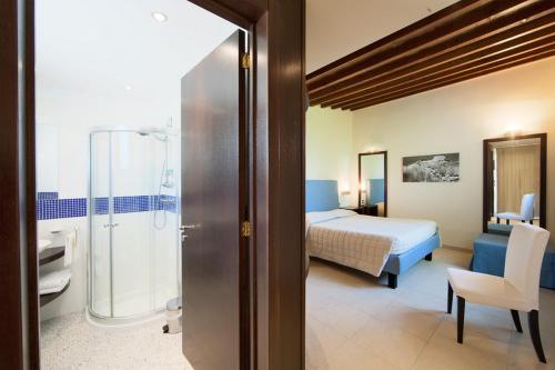 カヴァッリーノ・ディ・レッチェにあるB&B QuattroStelleのベッドとバスルーム付きのホテルルームです。