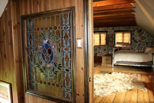 a room with a stained glass door with a bed at Maison du Mont-Mégantic spa à l'année in Lac-Mégantic
