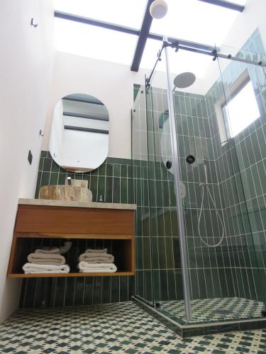 a bathroom with a shower with green tile at Ruca Lodge -Luxury Cabins Nestled in Nature in Uvita