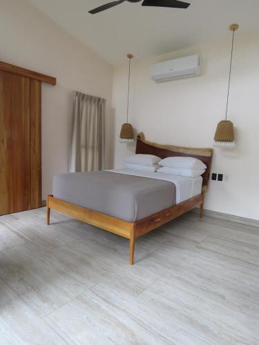 a bedroom with a large bed with white pillows at Ruca Lodge -Luxury Cabins Nestled in Nature in Uvita