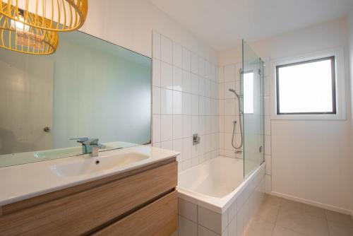 a bathroom with a tub and a sink and a shower at Tahana Villa - River View Retreat - 3 Bedroom in Oakura