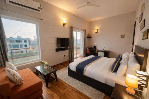 a hotel room with a bed and a large window at The Amber Signature Vrindavan # A Luxury Apartment With #Lift# Garden # Parking# Ac Rooms# & Elegant interior # Located Inside- Omaxe Eternity Vrindavan in Vrindāvan