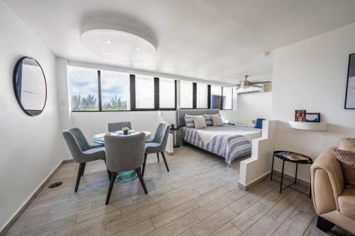 a living room with a bed and a table and chairs at Beachfront Bliss at Isla Verde in San Juan